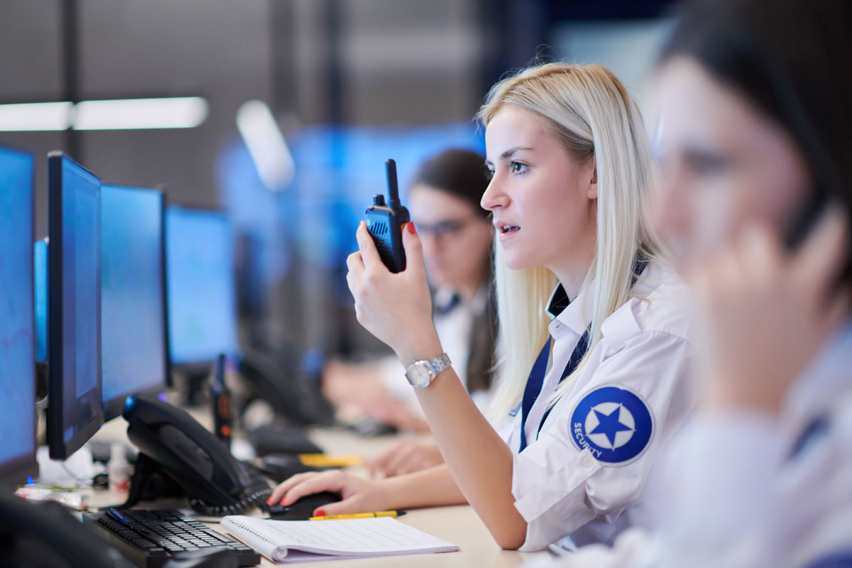 control room operator sitting at desk with multi-monitor setup